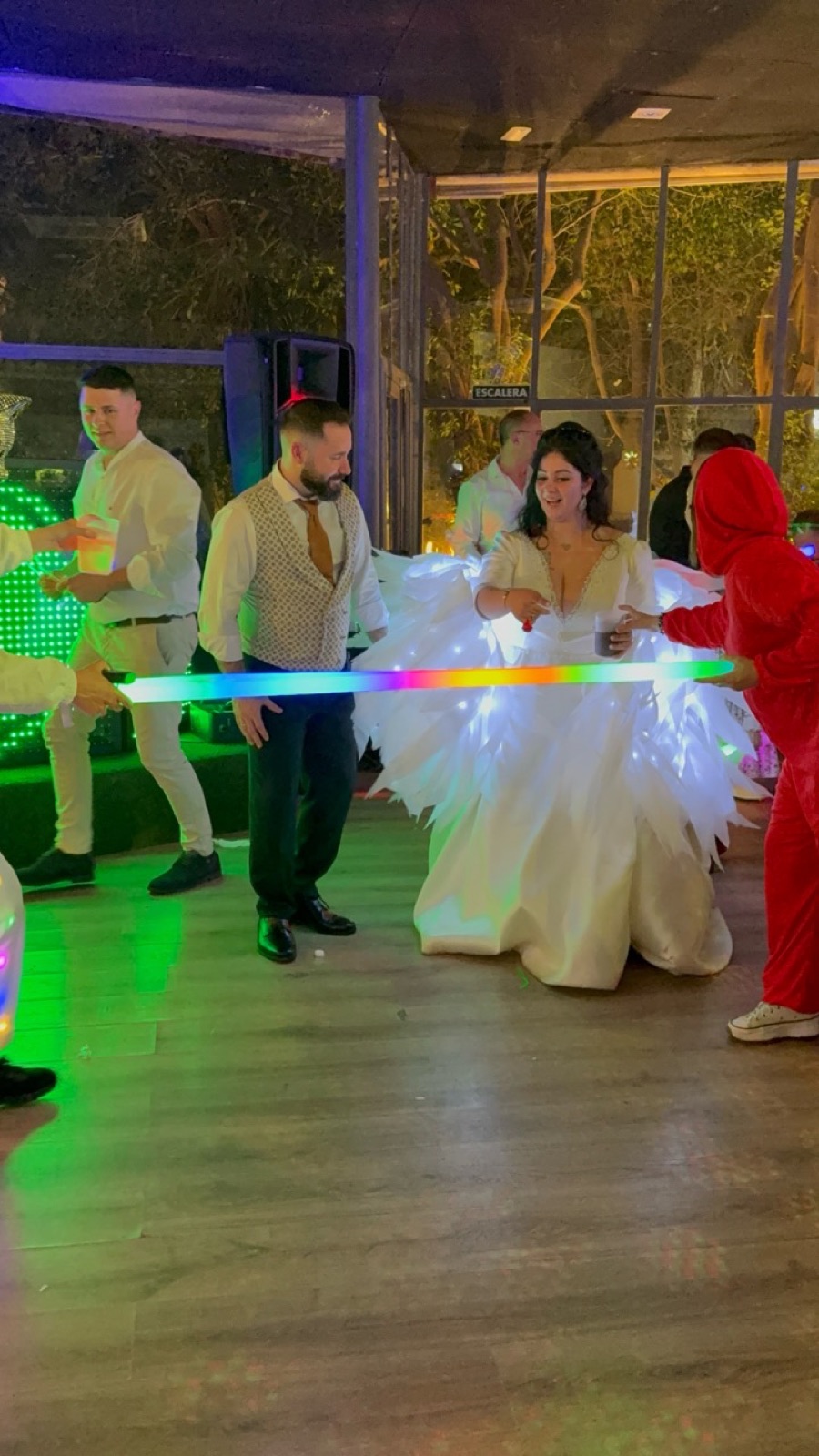 Novios participando en una Hora Loca con alas luminosas y atrezzo LED